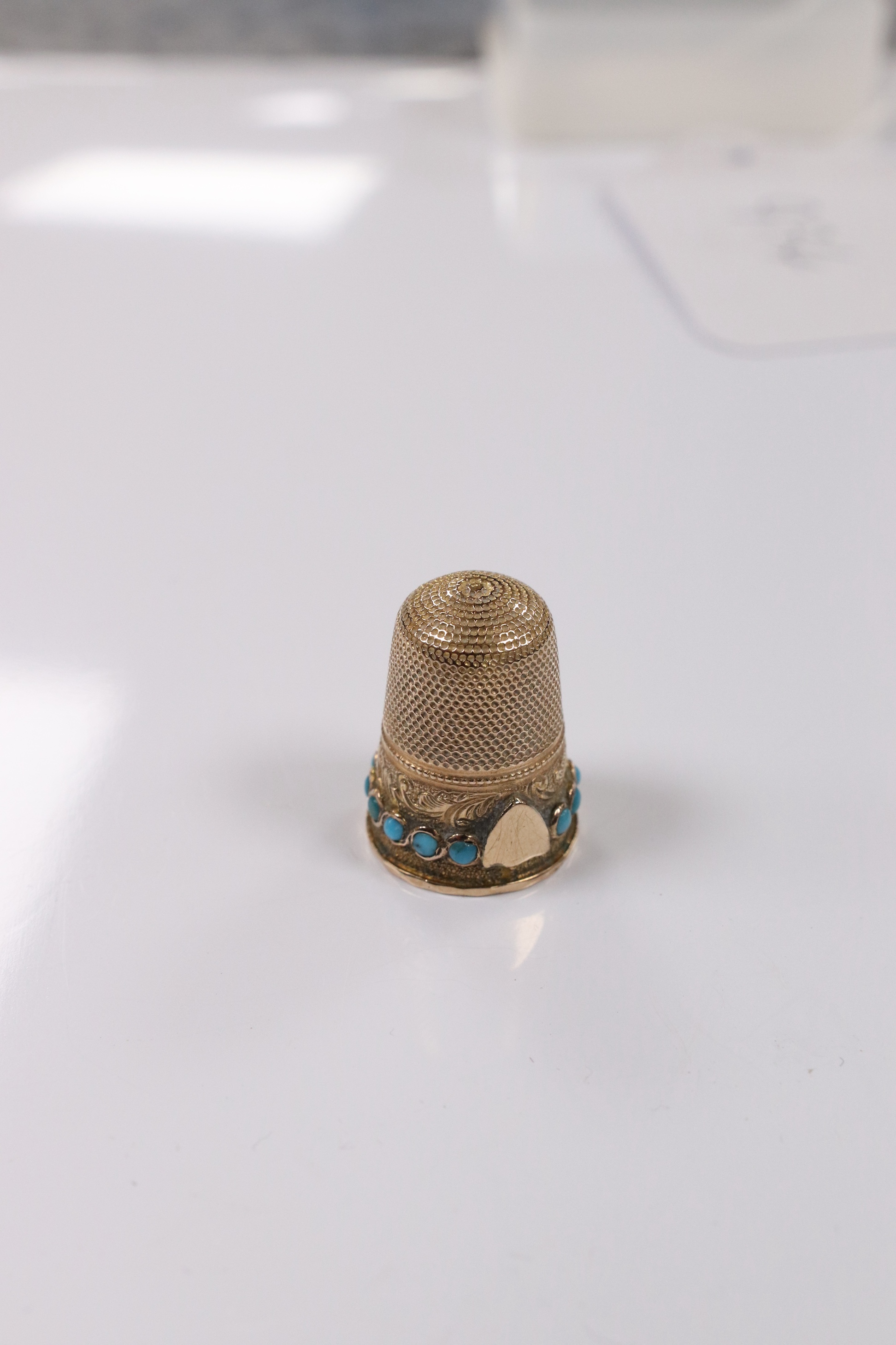 An antique yellow metal and turquoise set thimble, (stone missing), 21mm, gross weight 4,5 grams. Condition - poor to fair